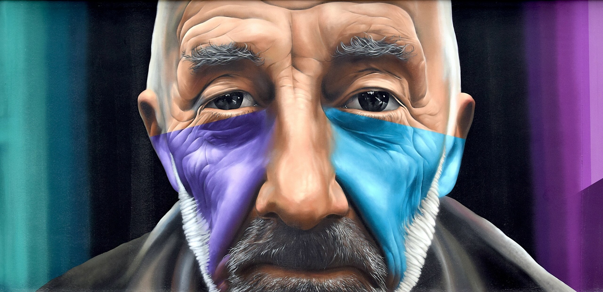 Part of the mural. Depicted is the face of a male read person with a beard, which represents the people who are in the square.